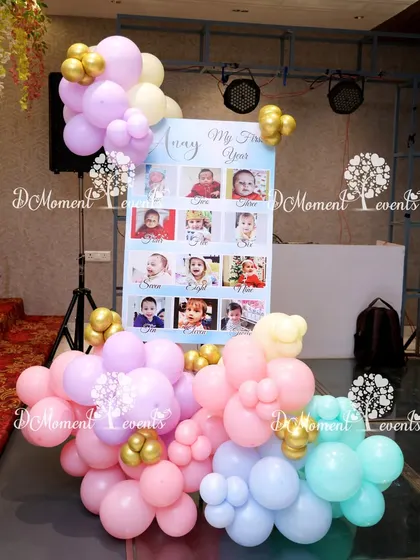 A sweet milestone board for a Candyland-themed party, surrounded by a cascade of pastel balloons.