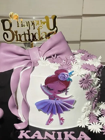For a little dancer, this ballerina-themed cake is a perfect choice. It features a beautiful edible ballerina illustration, delicate purple flowers, and a large, handcrafted fondant bow for an elegant and sweet touch.