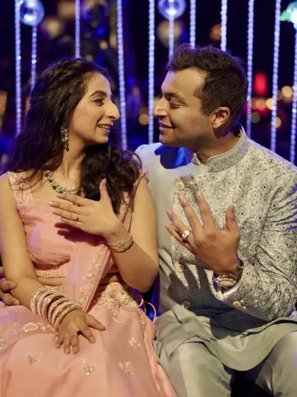 The newly engaged couple showing off their rings with big smiles.