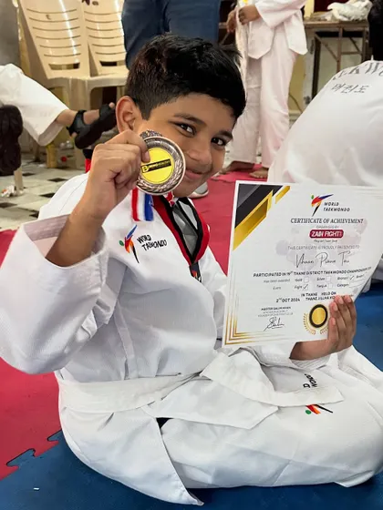 Great kudos to our winners. This young champion is proudly showing off his medal and certificate after a successful Taekwondo competition.
