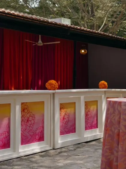 The bar counter for the Haldi is decorated with custom panels in shades of yellow and pink.