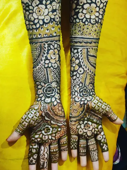 A beautiful Indian designer mehendi with a mix of floral and geometric patterns, highlighted by the use of negative space.