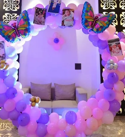 A circular balloon frame decorated with photos of the birthday girl. This is a creative and personal touch we can add to any party theme, like this butterfly celebration.