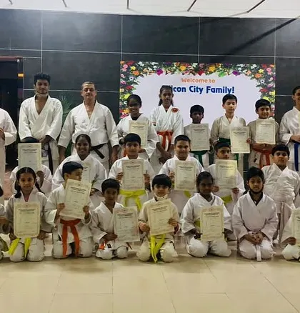 The full group of students from our Silicon City dojo posing with their new belts and certificates after a demanding but successful grading day.