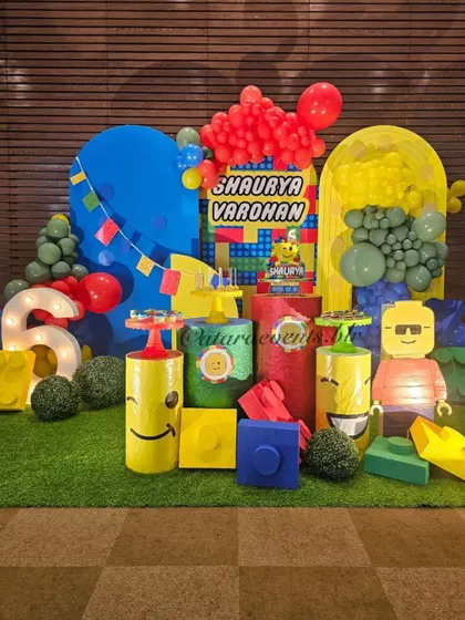 The main stage for this LEGO party is a builder's paradise, with a light-up number "6", large custom-built LEGO figures, and colorful block props on a grass-like floor.