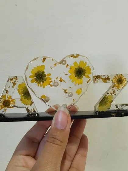 Holding the 'A heart Z' initial frame to show its size and the details of the embedded flowers.