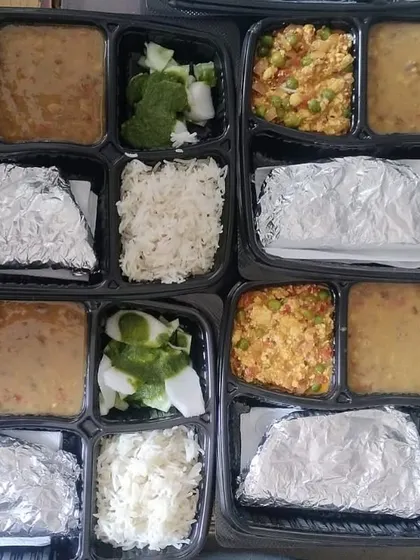 A large order of paneer bhurji and dal thalis. You can see the consistency in preparation and packing, ensuring everyone gets the same great taste.