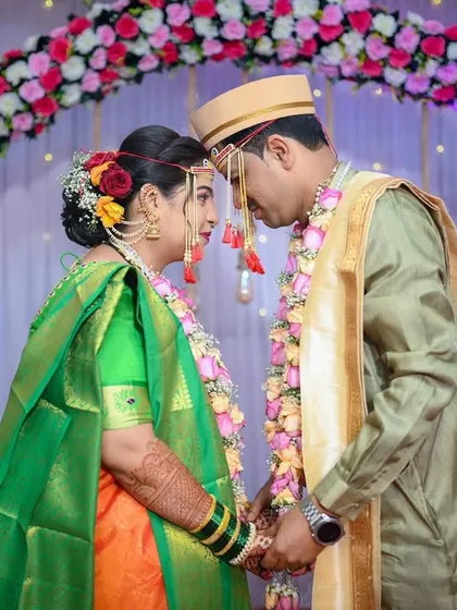 The couple sharing a moment forehead-to-forehead under the floral arch, a symbol of their new connection.