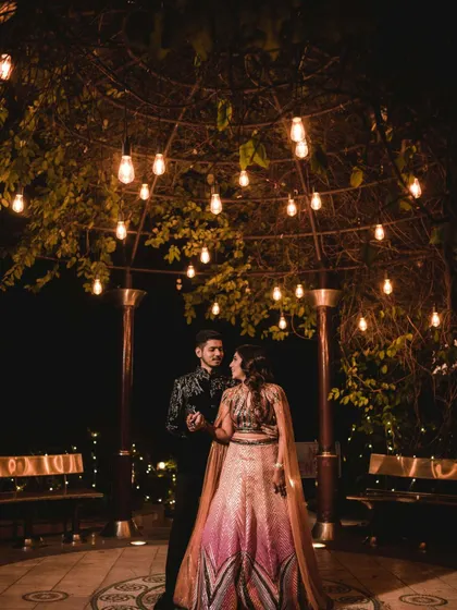 A wider shot of the same scene, showing the couple in a gentle dance under the lights, creating a fairy-tale-like moment.
