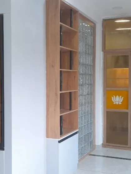 This completed project showcases a serene pooja area with custom glass doors featuring sacred symbols. The adjacent display unit with integrated lighting highlights our thoughtful space planning.