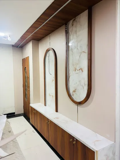 For this foyer, I designed a long shoe cabinet with a marble top and decorative wall panels to create a functional and stylish entrance gallery.
