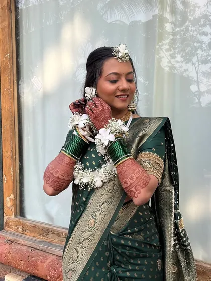 A close-up of the bride adjusting her floral earrings.
