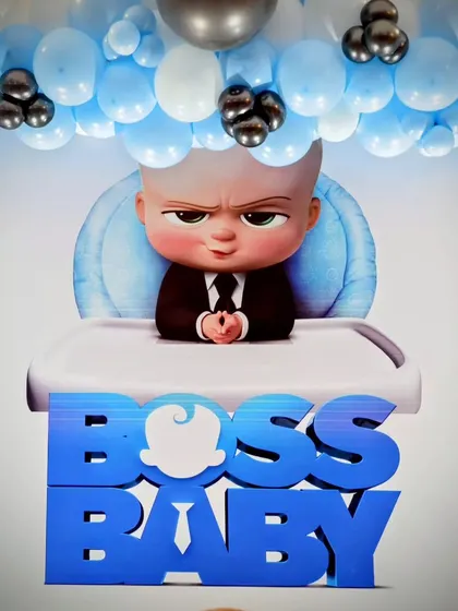 The main 'Boss Baby' logo on the backdrop, set under a blue and white balloon arch.