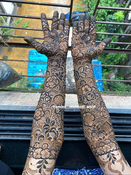 A stunning outdoor shot that captures the intricate details of this full-arm floral mehendi design.