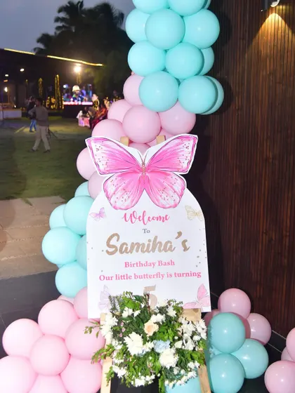Another view of the butterfly welcome board, surrounded by a pink and mint balloon garland.