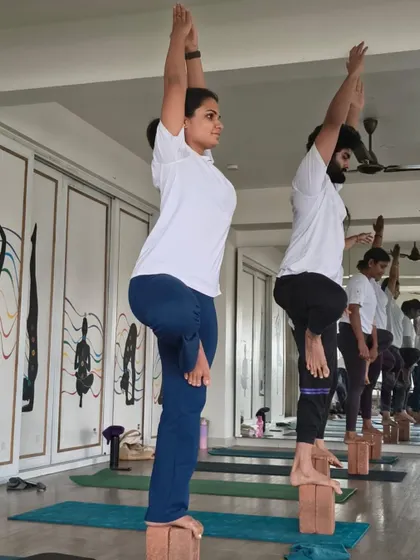 A close-up of students balancing on blocks, highlighting the concentration and strength required. This is a testament to the rigorous training in our TTC program.