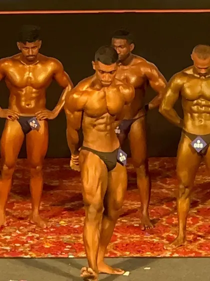 A classic physique pose on stage. Even though the category changed last minute, he brought his best-ever look and showcased it perfectly.