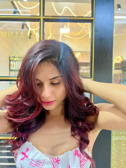 The final result of a stunning red hair makeover, styled with soft waves to showcase the color's dimension.