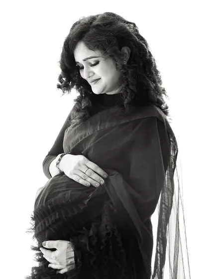A beautiful black and white portrait of a mom-to-be, showcasing the texture and form of the gown in a timeless style.