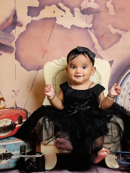 A happy little traveler ready for her next adventure. The vintage props and map backdrop create a wonderfully imaginative setting for a sitter session.
