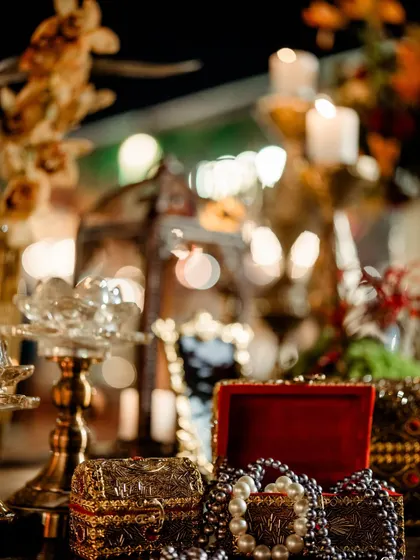 A soft-focus shot of vintage treasures and candlelight, creating a dreamy, opulent atmosphere. Every detail is a whisper of timeless elegance.