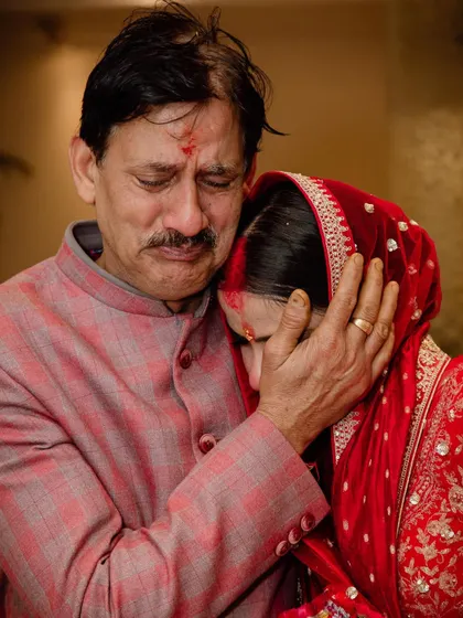 A deeply emotional and candid moment between a bride and her father, capturing the bittersweet tears of a Vidaai ceremony.