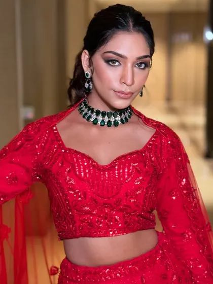 A bold and beautiful red lehenga paired with a striking emerald and diamond choker. This rental look is perfect for making a powerful statement at a sangeet or reception.