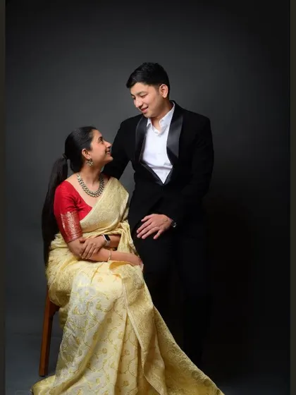 An elegant couple's portrait. The contrast between the traditional saree and the modern tuxedo creates a visually stunning and classic image.