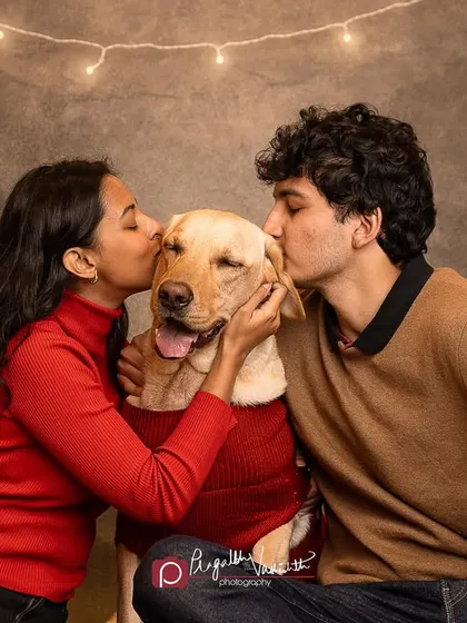 A double kiss for a very lucky and happy Labrador. This photo is overflowing with love and holiday cheer.