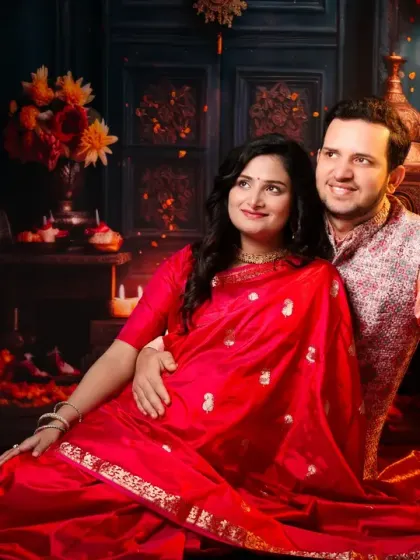 A stunning portrait of a couple in traditional Indian attire. They are seated amidst a beautifully lit, festive scene with candles and diyas, creating a magical and romantic atmosphere.