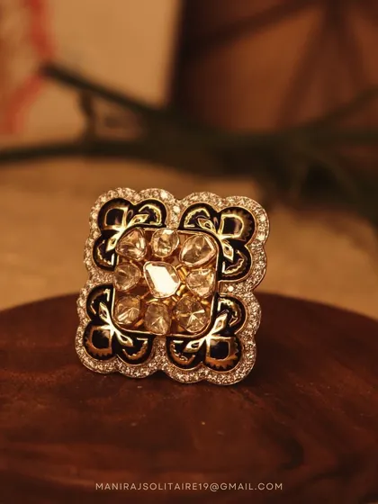 A bold and beautiful cocktail ring. This piece combines traditional Polki diamonds with intricate black enamel work and a halo of smaller diamonds. It's a perfect fusion of classic techniques and modern design.