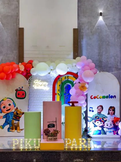 A vibrant and colorful Cocomelon birthday party. I use characters, a rainbow arch, and a "Happy Birthday" neon sign to bring the cheerful world of Cocomelon to life.