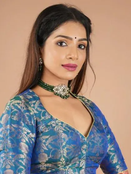 This model pairs a blue brocade blouse with a stunning green and white kundan-style choker.