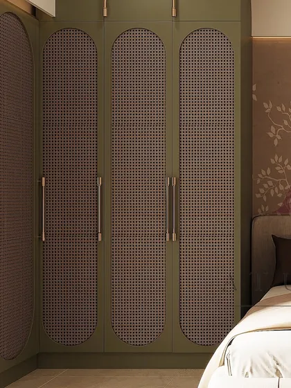 These olive green wardrobes feature unique arched doors with cane webbing, adding a touch of bohemian elegance to the bedroom.