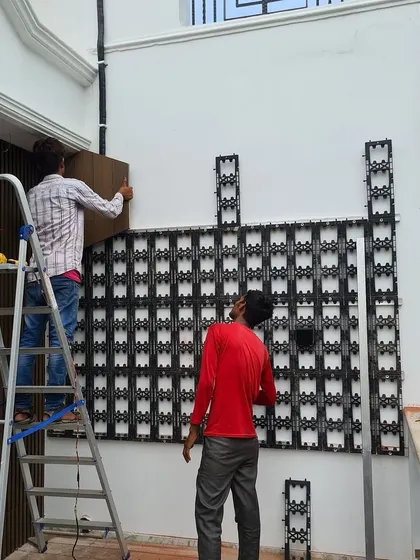 I believe in being transparent about my work. This photo shows my team during the installation of a vertical garden frame on a balcony. You can see the durable grid system we use, which forms the foundation for both our living and artificial green walls.