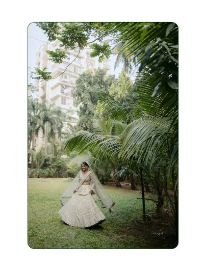 A joyful bridal portrait in a lush green garden. The bride is twirling, her veil flying, creating a sense of freedom and happiness.