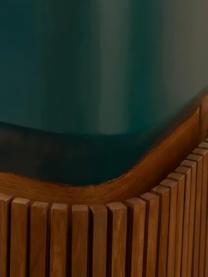 This detail from the Sanctum site office highlights the precise meeting of materials. The deep green of the planter box contrasts beautifully with the fluted texture and warm tones of the teak wood, showcasing our commitment to refined craftsmanship.