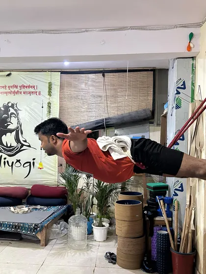 A student holds a challenging pose suspended by wall ropes. This builds immense core strength, back strength, and body awareness.