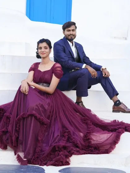 A stunning pre-wedding photo on a Santorini-themed set. The bride-to-be's flowing purple gown is the star of the show.
