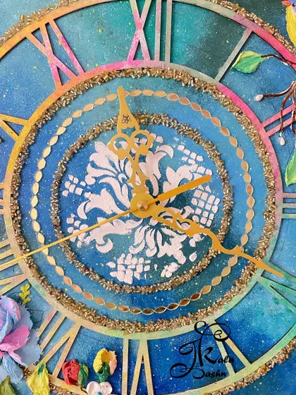 A detailed shot of the clock's center, where a white stencil pattern sits against the deep blue galaxy background. The golden hands and glitter-lined rings add a layer of sophistication.