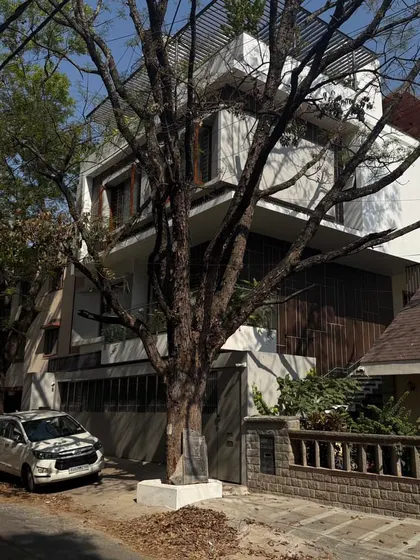 A view of a modern home from the street, designed to integrate with the existing trees and landscape, showcasing a balance between privacy and openness.