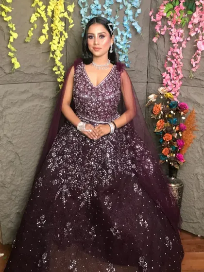 Make heads turn at your reception or cocktail party with this deep purple sequined gown. The intricate silver sparkle work catches the light beautifully, and the attached cape adds a touch of modern drama. It’s a glamorous look available for rent for your special night.