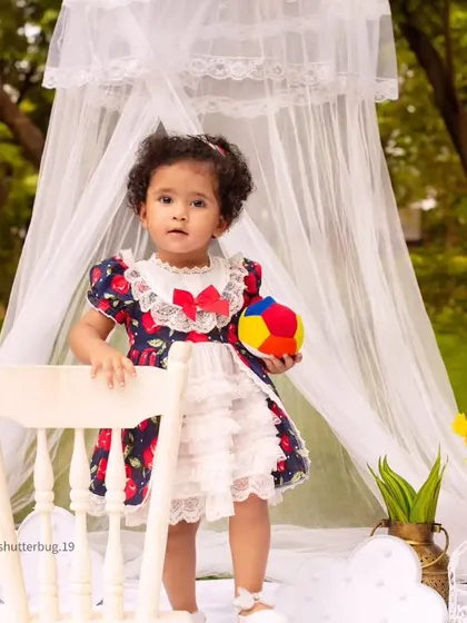 This little girl is standing tall and proud during her whimsical outdoor photoshoot with a sheer white canopy.