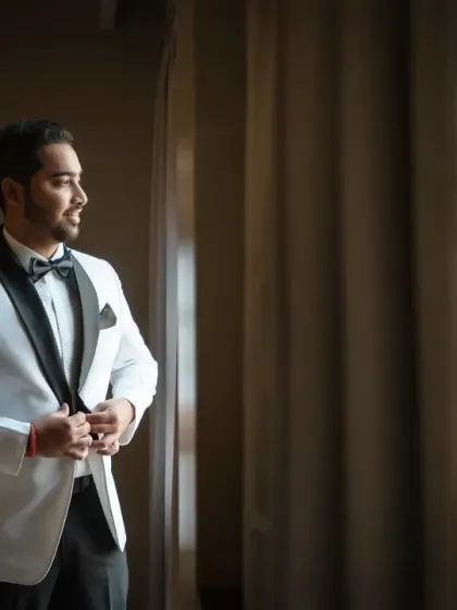 A classic groom portrait by the window. The dramatic lighting creates a sophisticated and timeless look, perfect for any wedding album.