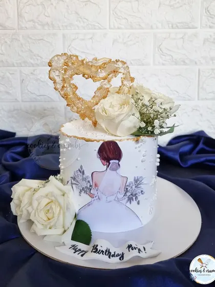A simple yet beautiful cake for a bride-to-be. This design features an edible print, a sparkling isomalt heart, and fresh white roses for a touch of elegance.
