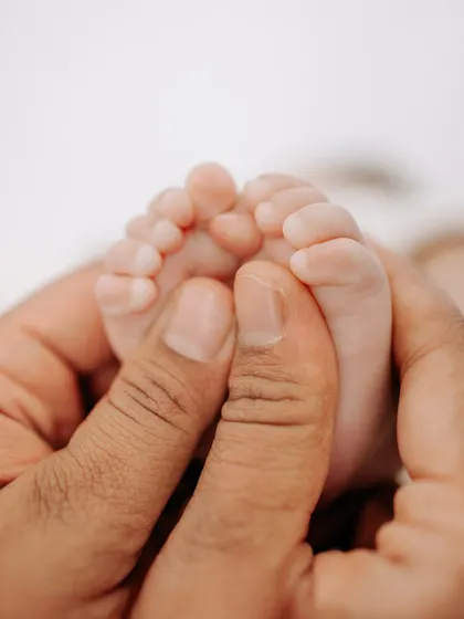 It's all about the little things that you'll want to remember forever. A father's hands gently holding his newborn's tiny feet is a simple, powerful image of love and protection.