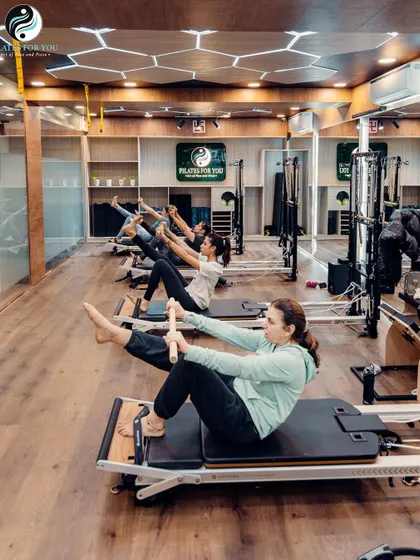 Here, clients are performing the "Hundred," a classic Pilates exercise that warms up the body and deeply engages the abdominal muscles. It's a staple in many of our group sessions.
