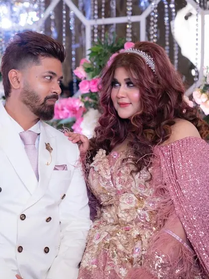 Hey, Husband. A candid, happy moment with my partner against the beautiful floral backdrop of our reception.