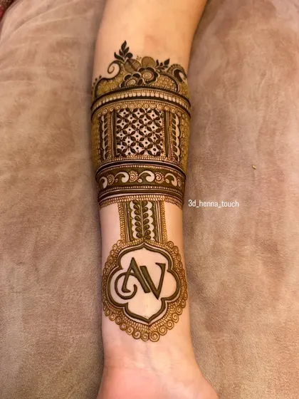 The arm band design with the 'AV' initial monogram as the centerpiece. The surrounding patterns are designed to complement and highlight the personalized element.