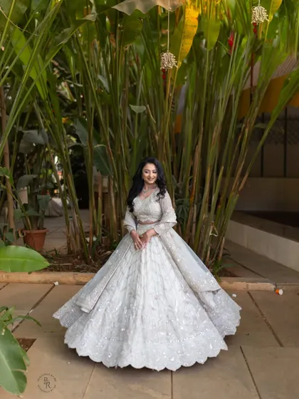 The bride looks radiant in her flowing white lehenga, a perfect outfit for an elegant engagement or reception.